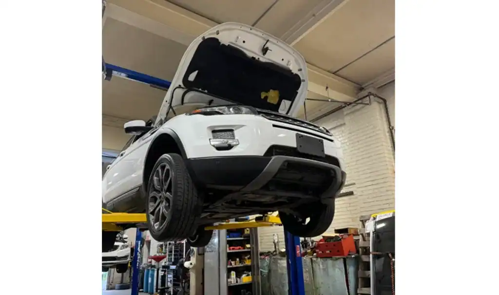White SUV lifted in bright service bay at Integrated Automotive Services, Easton