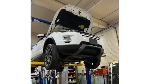White SUV lifted in bright service bay at Integrated Automotive Services, Easton