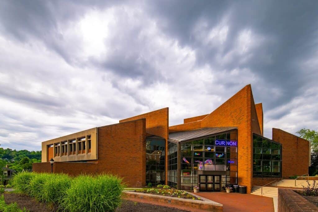 Exterior view of the Williams Center for the Arts with modern brick architecture and large glass windows under a cloudy sky.
