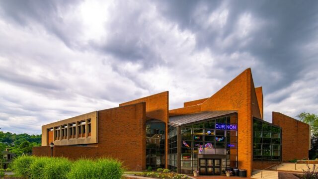 Exterior view of the Williams Center for the Arts with modern brick architecture and large glass windows under a cloudy sky.