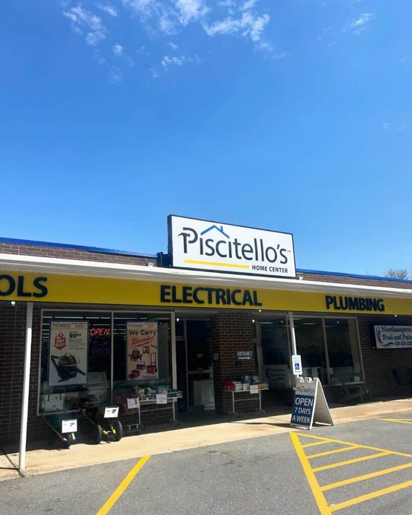 Exterior view of Piscitello's Home Center showing electrical and plumbing supplies, with a bright blue sky and store signage.