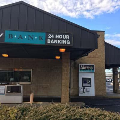 Unity Bank branch with 24-hour banking service and ATM outside, located in Easton, featuring a black awning and brick exterior.