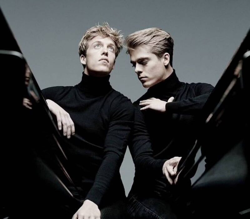 Orpheus Chamber Orchestra with guest artists Lucas and Arthur Jussen performing on stage in black attire, focused and expressive.